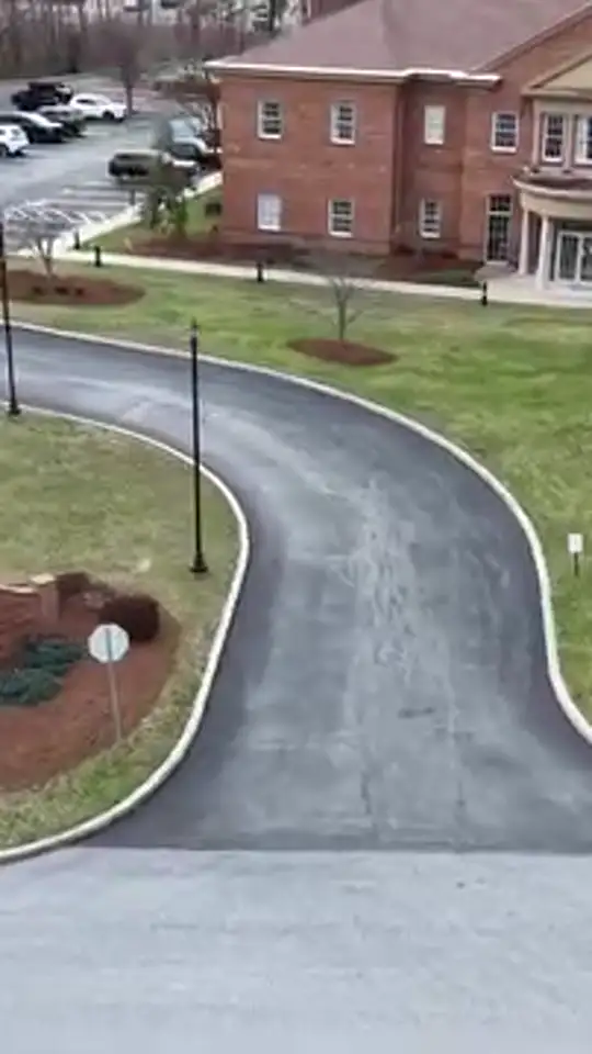 Lawn, mulch beds and tree rings around a commercial building and driveway